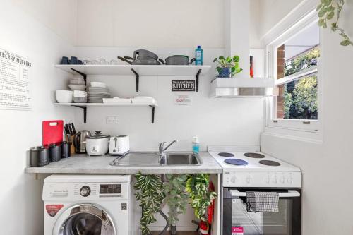 a kitchen with a sink and a washing machine at Courtyard Double Room - Next to Transport & Shops in Killara - Shared Bathroom in Killara