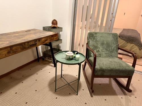 a desk with a chair and a table with a cup on it at The Grand Book Nook Retro Stay - Luxury King mattress with Flat TV - Private walk in book lounge & Study in Sydney