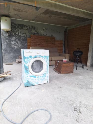 a washing machine sitting on the floor in a room at VILLA AICHY in Rabi