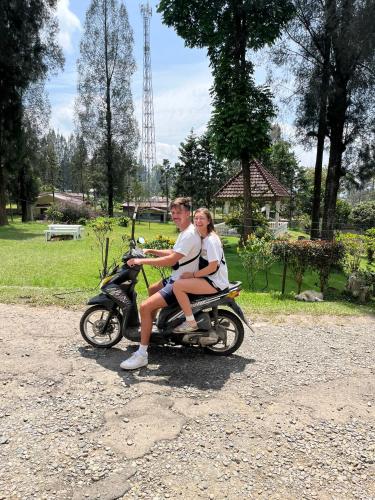a man and a woman riding on a motorcycle at Sibayak Multinational Rest House in Berastagi