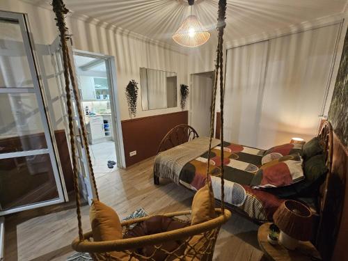 a room with a swing with a bed and a window at TropiKana in Evry-Courcouronnes