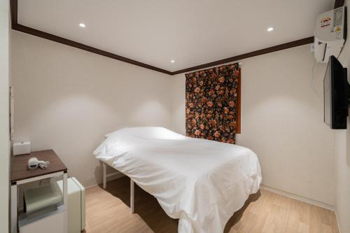 a bedroom with a white bed and a window at Life in Cheonggye in Seoul