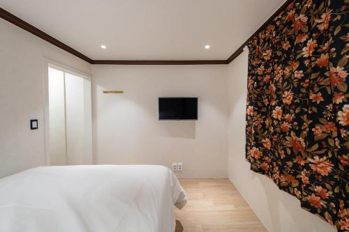 a bedroom with a floral tapestry on the wall at Life in Cheonggye in Seoul