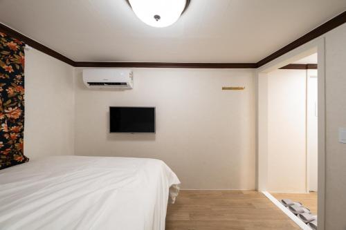 a bedroom with a bed and a tv on the wall at Life in Cheonggye in Seoul