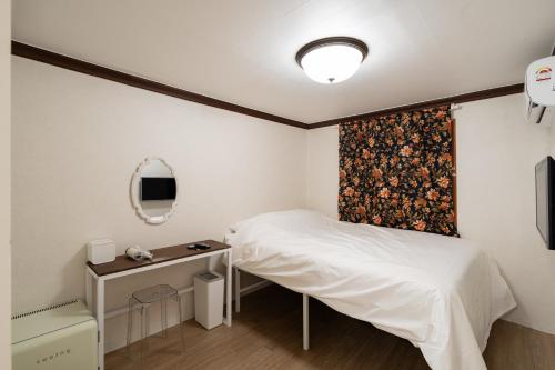 a bedroom with a bed and a desk and a mirror at Life in Cheonggye in Seoul