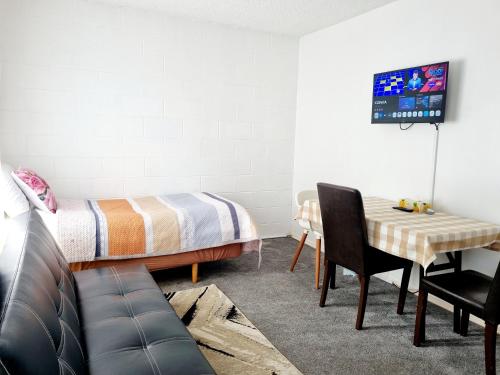 a bedroom with a bed and a table and a chair at Cedar Lodge Motel Hamilton in Hamilton