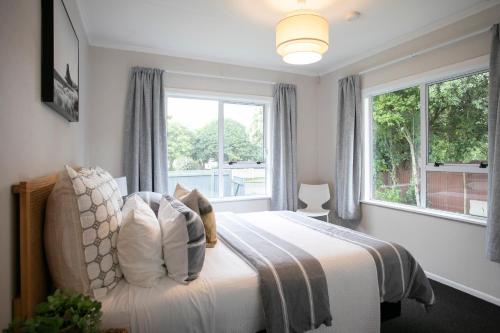 a bedroom with a bed with a large window at Riverbreeze Retreat in Palmerston North
