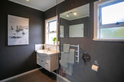 a bathroom with a sink and a mirror at Riverbreeze Retreat in Palmerston North