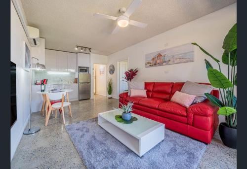 a living room with a red couch and a table at Stunning Apartment by the Beach in Port Macquarie