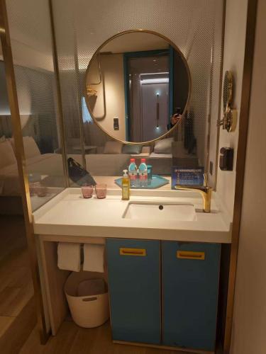 a bathroom with a sink and a mirror at Beijing Manxin Temple of Heaven North Gate Hotel in Beijing