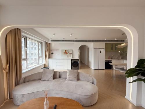 un salon avec un canapé et une cuisine dans l'établissement Urban Hub French premium Apart-ment Convenient Luxury 3 Bedroom Shanghai, à Shanghai