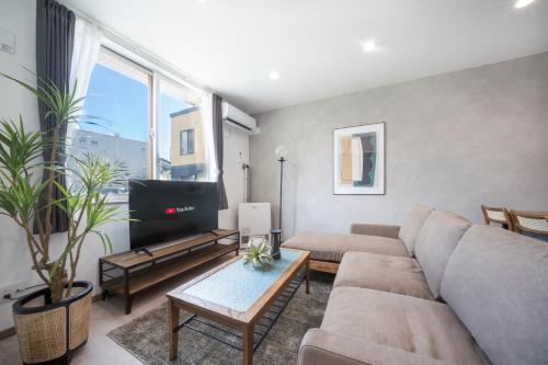 a living room with a couch and a tv at Mks 102 in Asahikawa