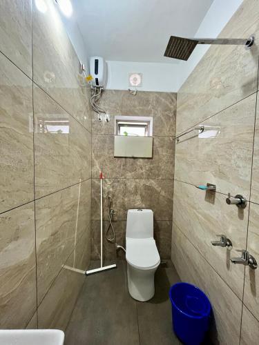 a bathroom with a toilet and a glass shower at Ayat Apartments - near to Rajagiri Hospital in Alwaye