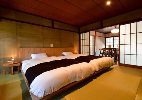 a bedroom with a large bed in a room with windows at Temple-stay WAQOO Mii-dera Vacation STAY 7052 in Otsu
