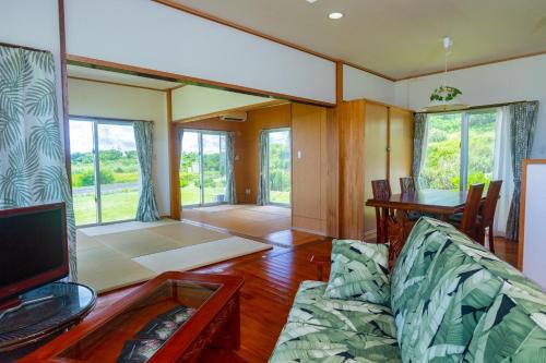 a living room with a couch and a table at Condominium de Urmanchu / Vacation STAY 79737 in Nakijin