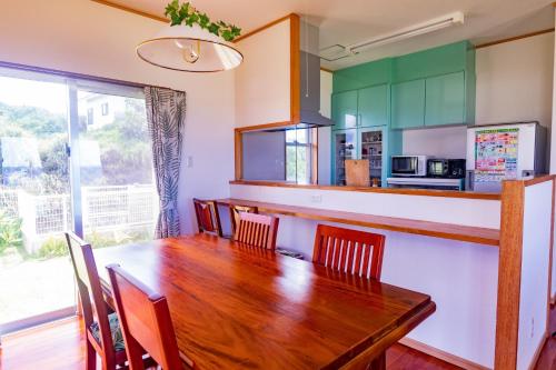 a dining room with a wooden table and chairs at Condominium de Urmanchu / Vacation STAY 79737 in Nakijin