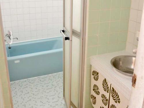 ein Badezimmer mit einer blauen Badewanne und einem Waschbecken in der Unterkunft Homa Ishigakijima no Yado - Vacation STAY 80173 in Ishigaki-jima