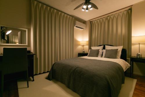 a bedroom with a bed and a ceiling fan at Naha - House / Vacation STAY 79997 in Naha