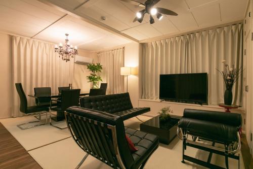 a living room with green chairs and a flat screen tv at Naha - House / Vacation STAY 79997 in Naha