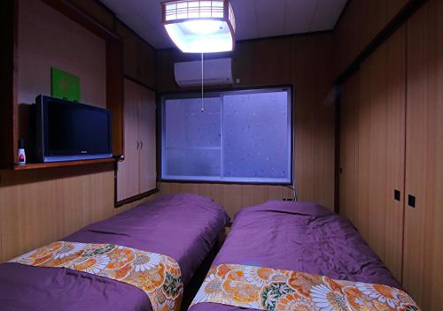two beds in a room with a large window at Kyoto - House / Vacation STAY 80314 in Kyoto