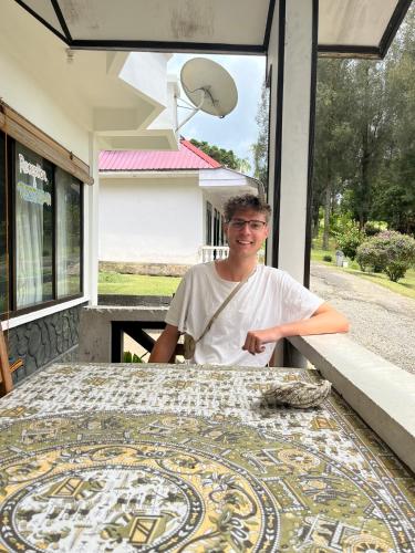 a man standing next to a table with a mosaic floor at Sibayak Multinational Rest House in Berastagi