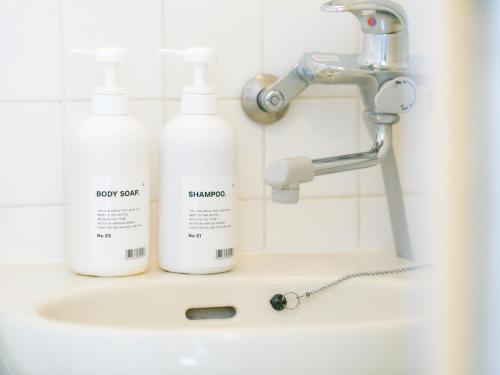a bathroom sink with two bottles of soap and a faucet at Aiwa Mansion / Vacation STAY 80383 in Naha