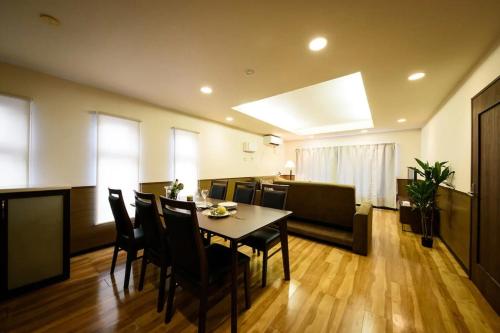a dining room and living room with a table and chairs at Dynasty Palace Nijyuuyonken / Vacation STAY 7377 in Sapporo