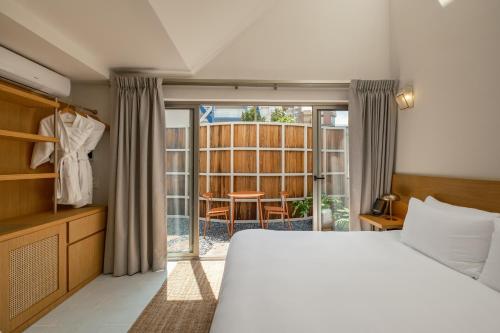 a bedroom with a bed and a sliding glass door at Cholula Condesa Hotel by Lumina in Mexico City