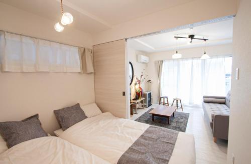 a bedroom with a bed and a living room at Premiere N21 / Vacation STAY 7452 in Sapporo