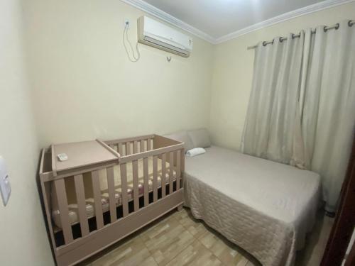 a small bedroom with a crib and a air conditioner at Casa do RIO in Barreirinhas