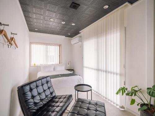 a bedroom with a bed and a chair at 1-21-19 / Vacation STAY 80184 in Urasoe