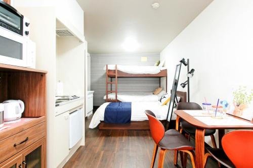 ein kleines Schlafzimmer mit einem Etagenbett und einem Tisch und Stühlen in der Unterkunft Heights N7 / Vacation STAY 7568 in Sapporo