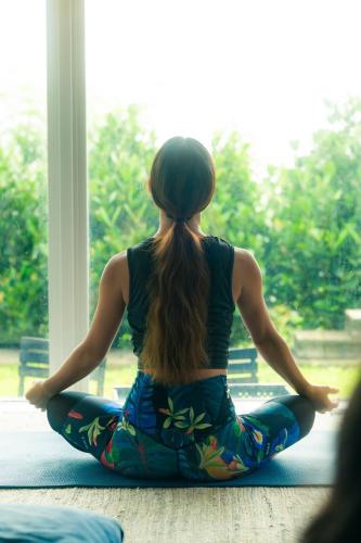 a woman sitting in a yoga pose looking out a window at "NICE!" Ocean view of Ishigaki island, Okinawa/ Four-bedroom Villa in Ishigaki Island