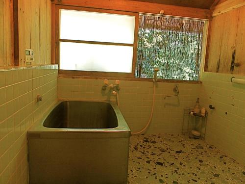 a dirty bathroom with a sink and a window at Kominka Sharehouse Hooju - Vacation STAY 10518 in Miyazaki