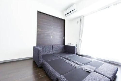 ein Sofa in einem Zimmer mit einer Wand in der Unterkunft Suncourt Hondori Garden Hills / Vacation STAY 7593 in Sapporo