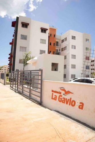 a fence in front of a building with a sign at Cozy Palace in Los Paredones