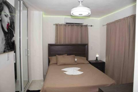 a bedroom with a bed with a white hat on it at Cozy Palace in Los Paredones