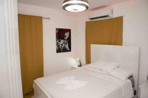 a bedroom with a white bed in a room at Cozy Palace in Los Paredones