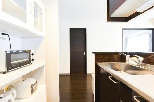 Suncourt Hondori Garden Hills / Vacation STAY 7592 في سابورو: مطبخ مع حوض وميكروويف