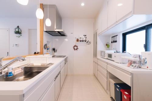 a kitchen with white cabinets and a sink at Nakagami-gun - House / Vacation STAY 80729 in Jima