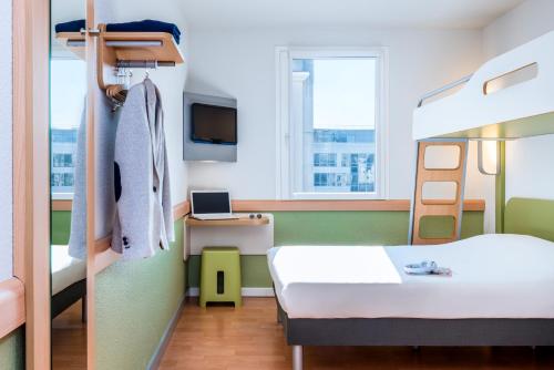 um quarto com uma cama e um beliche em Ibis Budget Clermont Ferrand - Le Brezet - Aeroport em Clermont-Ferrand