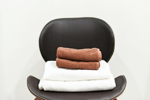 a black chair with a stack of towels at Heights N7 / Vacation STAY 7570 in Sapporo