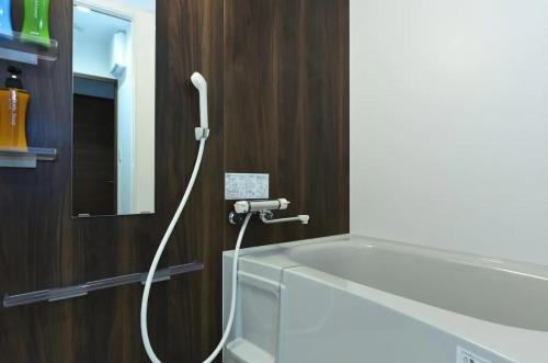 a bathroom with a bath tub with a hose at Hills Garden Hondori / Vacation STAY 7577 in Sapporo