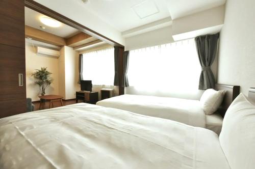 a hotel room with two beds and a window at Hills Garden Hondori / Vacation STAY 7577 in Sapporo