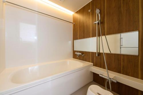 a bathroom with a bath tub and a toilet at BEYOND HOTEL Takayama 3rd - Vacation STAY 82217 in Takayama