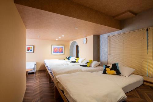 a row of white beds in a room at BEYOND HOTEL Takayama 2nd - Vacation STAY 82265 in Takayama