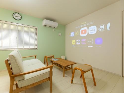 a room with a chair and a table and a clock at Kinugawa Station Front room A in Nikko