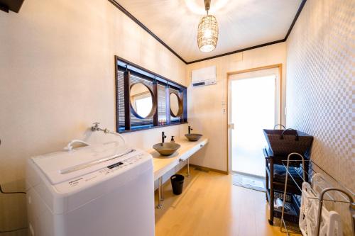 eine Waschküche mit einem Waschbecken und einer Waschmaschine in der Unterkunft Minamitsuru-gun - House - Vacation STAY 82324 in Fujikawaguchiko
