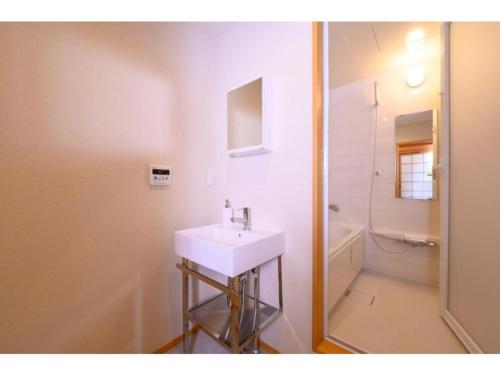 a white bathroom with a sink and a shower at BEYOND HOTEL Takayama 4th - Vacation STAY 82226 in Takayama