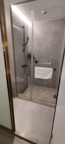 a bathroom with a glass shower with a white towel at Atour Light Hotel Shanghai Xujiahui Jiaotong University in Shanghai